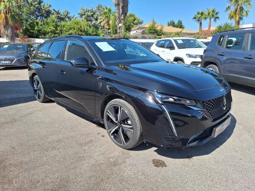 Peugeot 308 SW Hybrid 145 GT noir vue 3/4 avant avec barres de toit et jantes alliage 18 pouces.