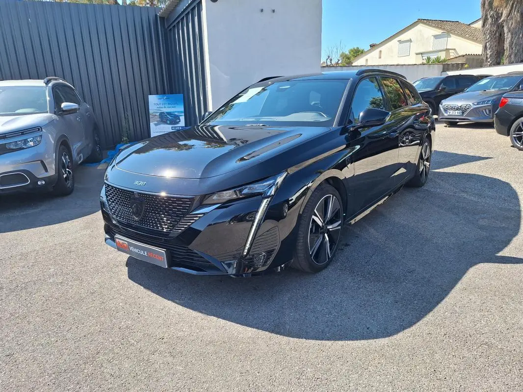 Peugeot 308 SW Hybrid 145 e-DCS6 GT noir vue 3/4 avant avec barres de toit et jantes alliage 18 pouces.