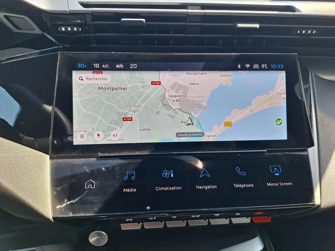 Vue rapprochée de l’écran tactile central du Peugeot 308 SW Hybrid 145 e-DCS6 GT affichant la navigation et les commandes multimédia.