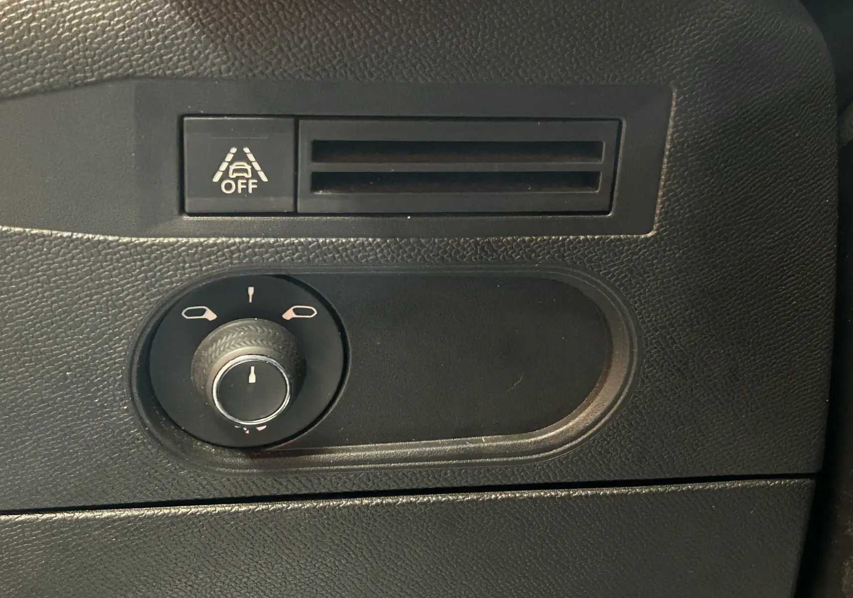 Détail du tableau de bord avec commande de réglage des rétroviseurs et bouton de désactivation de l'alerte de franchissement de ligne.