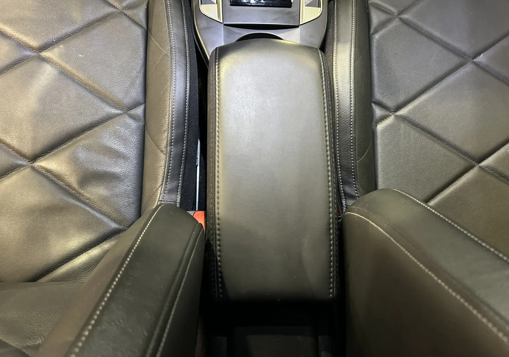 Vue rapprochée de l'accoudoir central en cuir noir entre les sièges avant du DS3 Crossback Bleu Millenium.