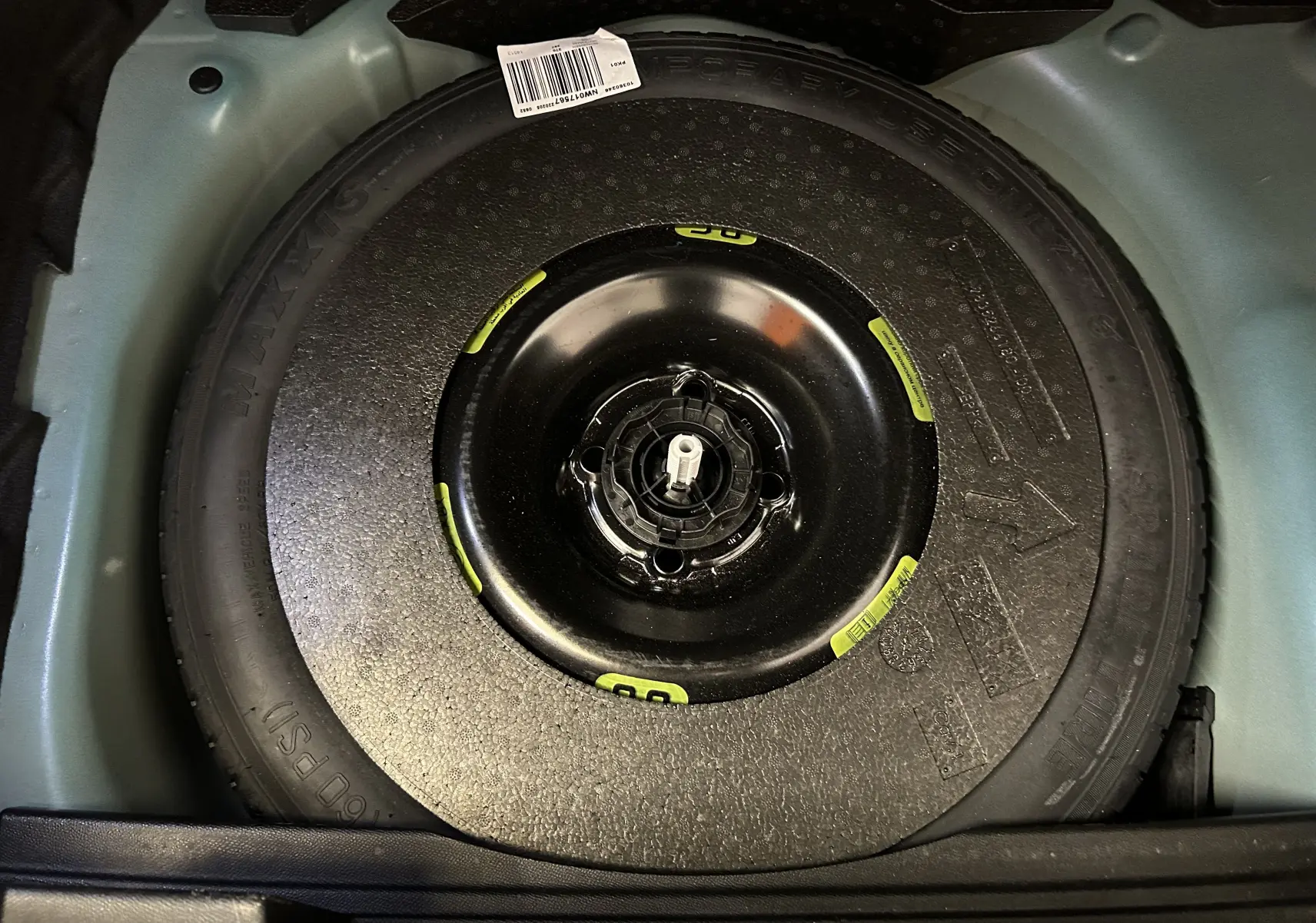 Roue de secours noire installée dans le coffre d’un DS3 Crossback Bleu Millenium, vue en plongée.