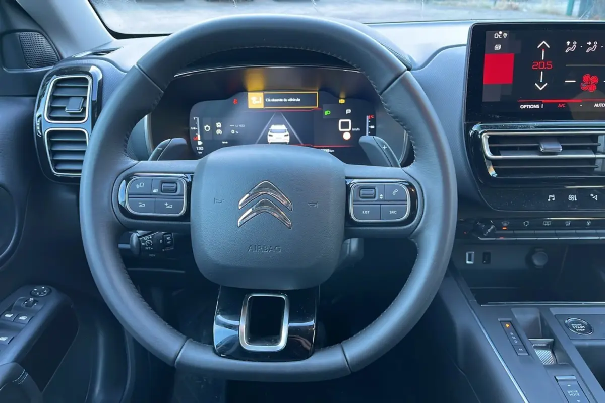 Vue centrée sur le volant cuir multifonctions du Citroën C5 Aircross Hybrid 2025 avec tableau de bord digital et écran tactile.