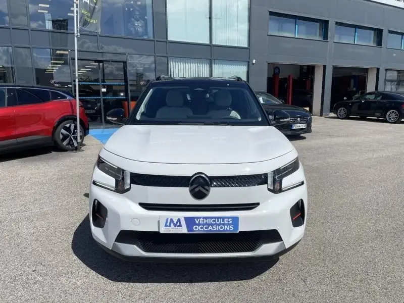 Vue avant d'une Citroën C3 Nouvelle blanche 2025 avec logo noir et plaque "Véhicules Occasions" sur parking.