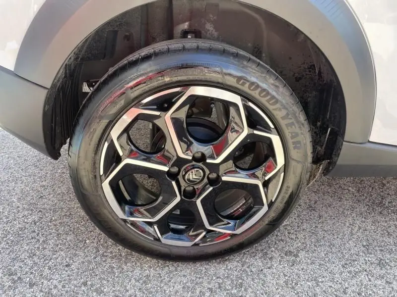 Gros plan sur la roue avant droite d’une Citroën C3 Nouvelle blanche 2025 avec jante alliage noire et argentée au design géométrique.