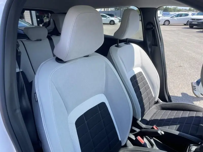 Vue intérieure de la Citroën C3 Nouvelle 2025, sièges avant bicolores gris clair et noir, porte ouverte côté droit.