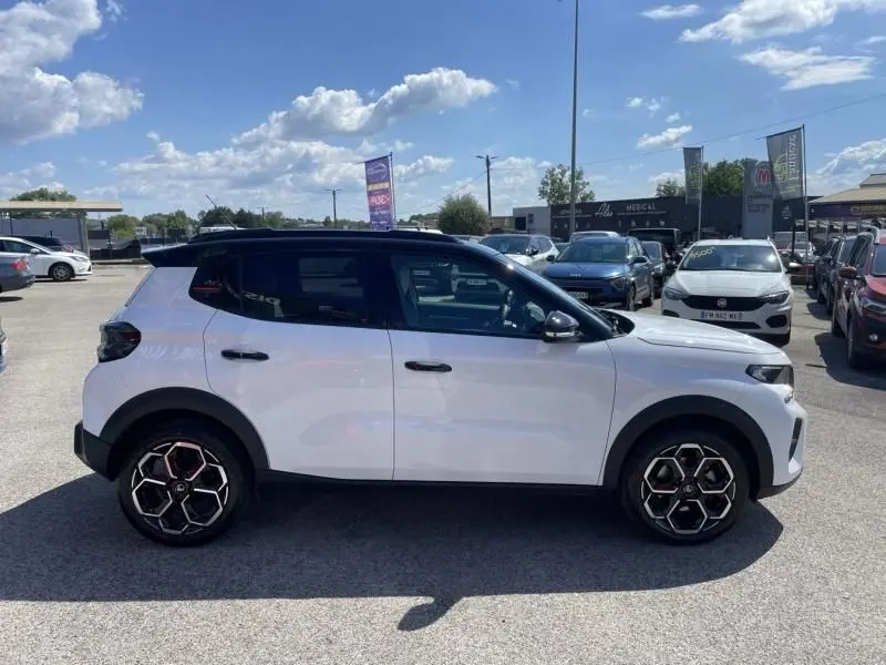 Vue de profil côté gauche d'une Citroën C3 Nouvelle blanche 2025 avec toit noir et jantes au design hexagonal.