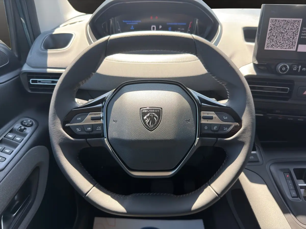 Vue rapprochée du volant cuir noir du Peugeot Rifter 2026 avec commandes multifonctions et tableau de bord numérique.