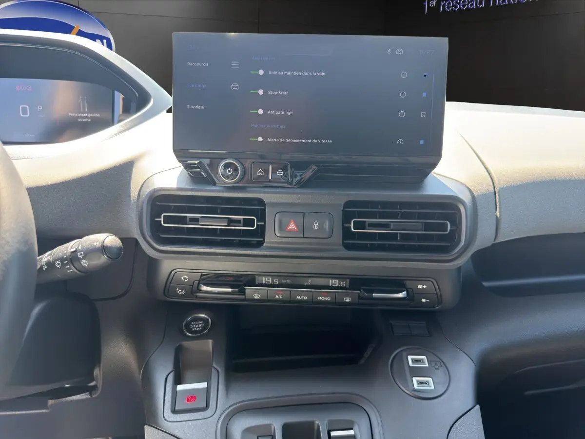 Vue intérieure du tableau de bord du Peugeot Rifter 2026, avec écran tactile central et commandes de climatisation.