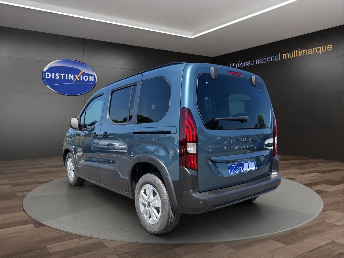 Peugeot Rifter bleu vue 3/4 arrière droit, mettant en valeur ses feux arrière distinctifs et ses vitres teintées.