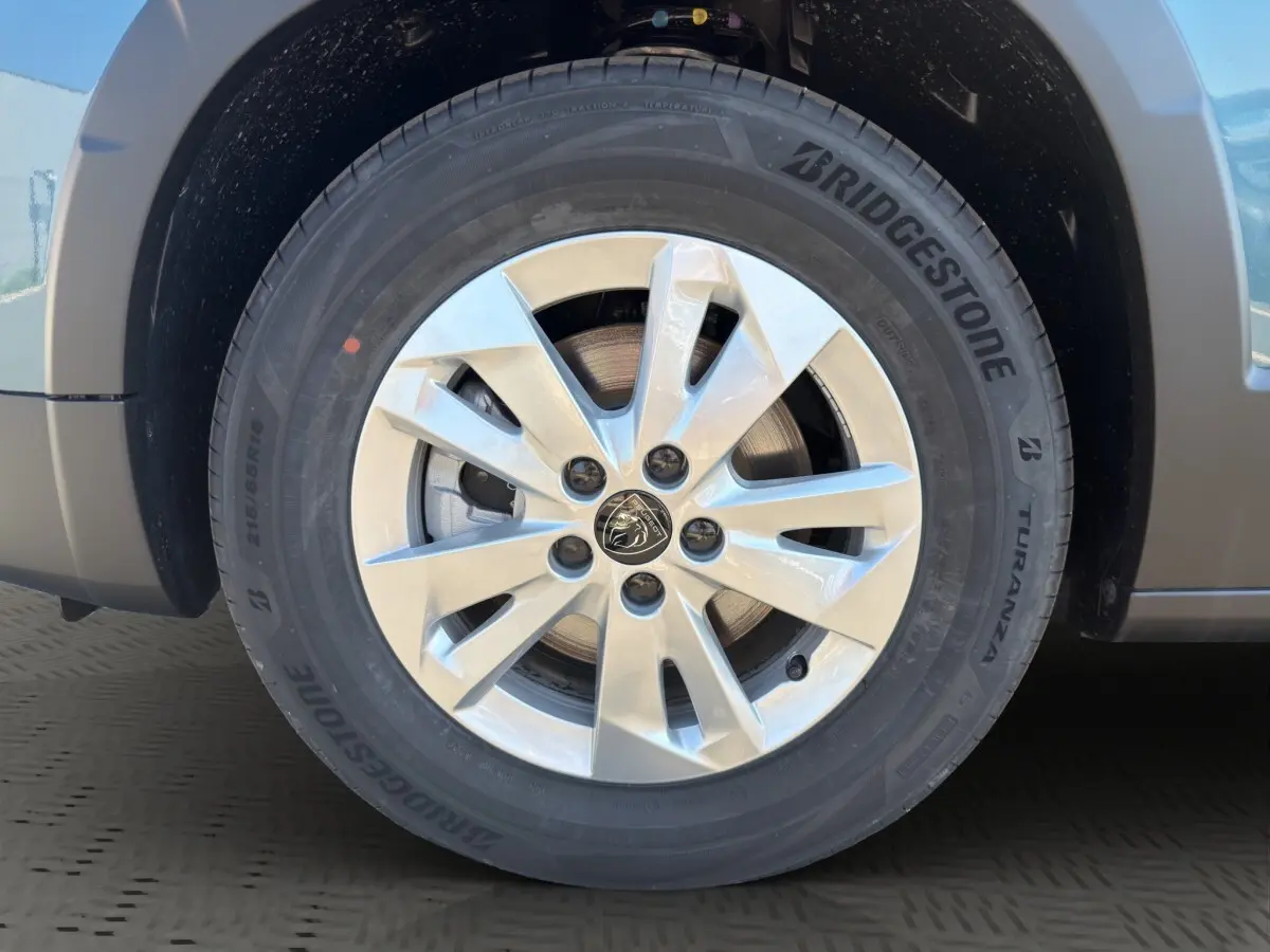 Gros plan sur la roue avant droite du Peugeot Rifter bleu, avec jante alliage et pneu Bridgestone Turanza.