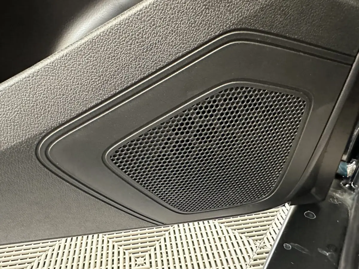 Gros plan sur le haut-parleur intégré dans la porte intérieure noire d'une Aixam Ambition 0.5 City Pack 2025.