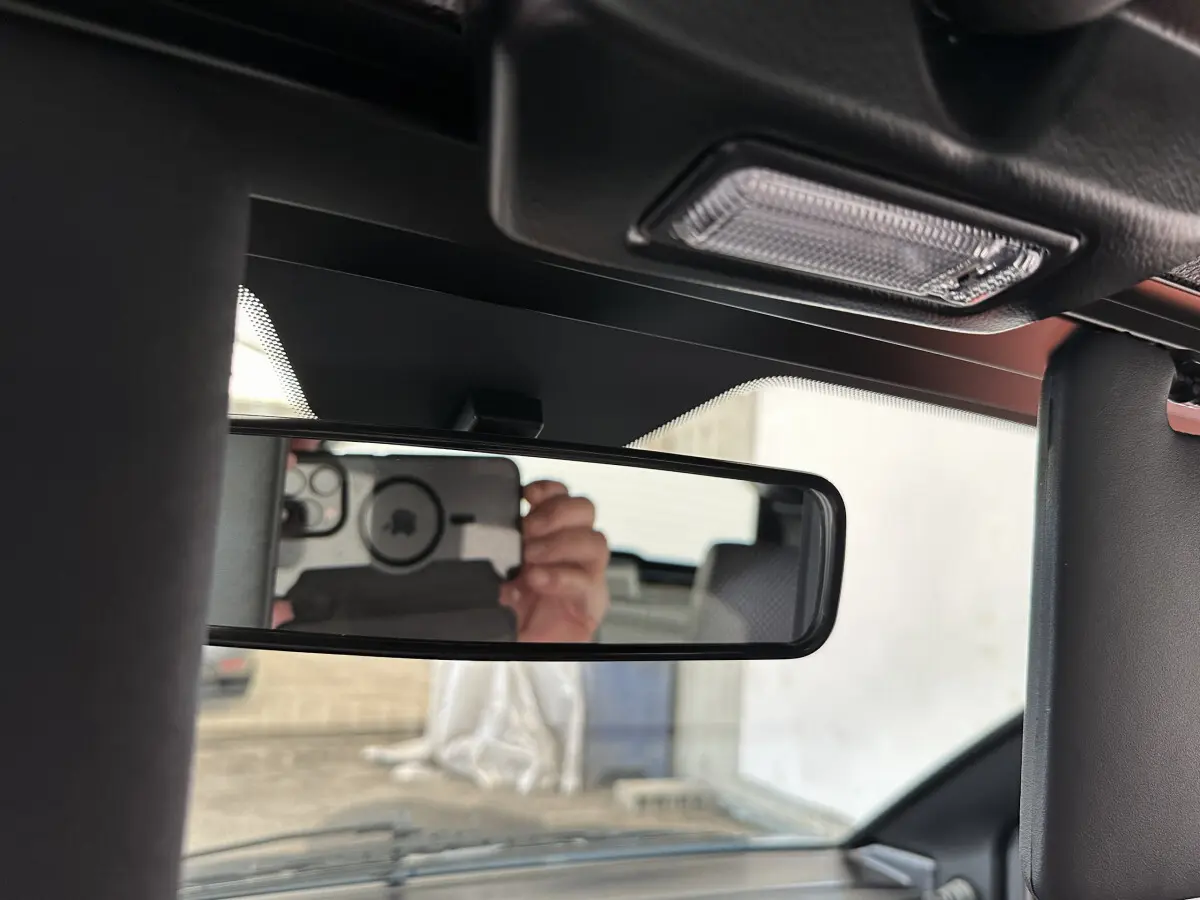 Vue intérieure du rétroviseur central d'une Aixam Ambition 0.5 City Pack 2025 avec caméra côté conducteur visible en reflet.