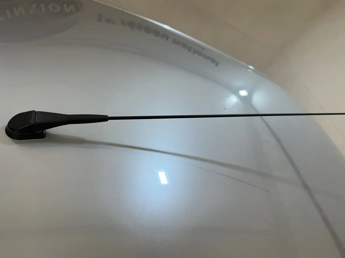 Gros plan sur l'antenne radio noire sur le toit bleu d'une Aixam Ambition 0.5 City Pack 2025 vue de dessus.