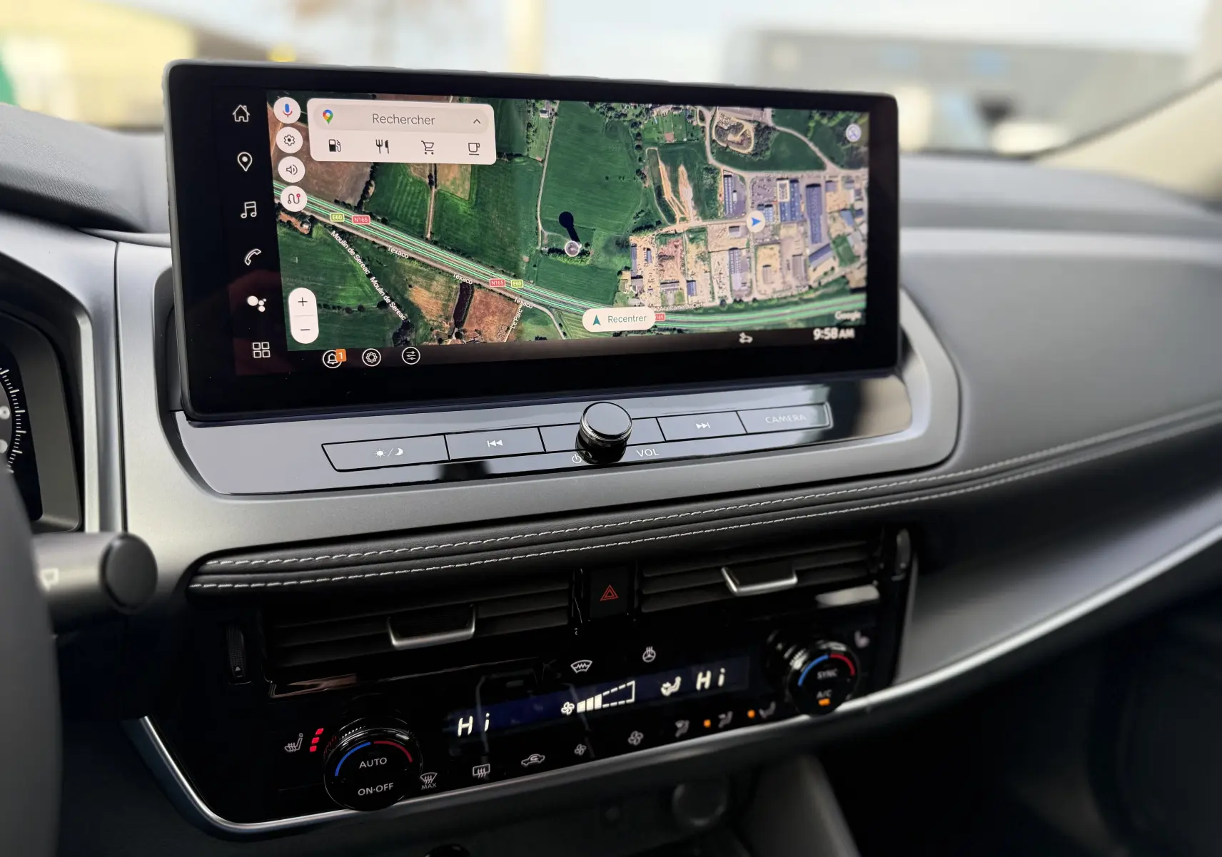 Vue rapprochée de la console centrale du Nissan Qashqai 2025 gris, avec écran tactile affichant une carte GPS.