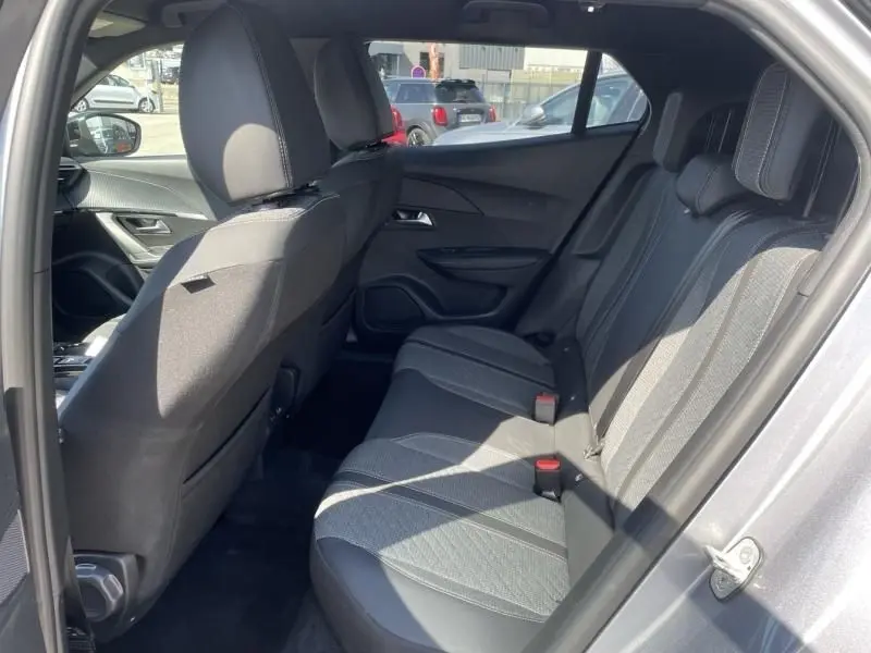 Vue intérieure arrière côté droit du Peugeot 2008 gris métal 2025, montrant les sièges arrière et la porte ouverte.