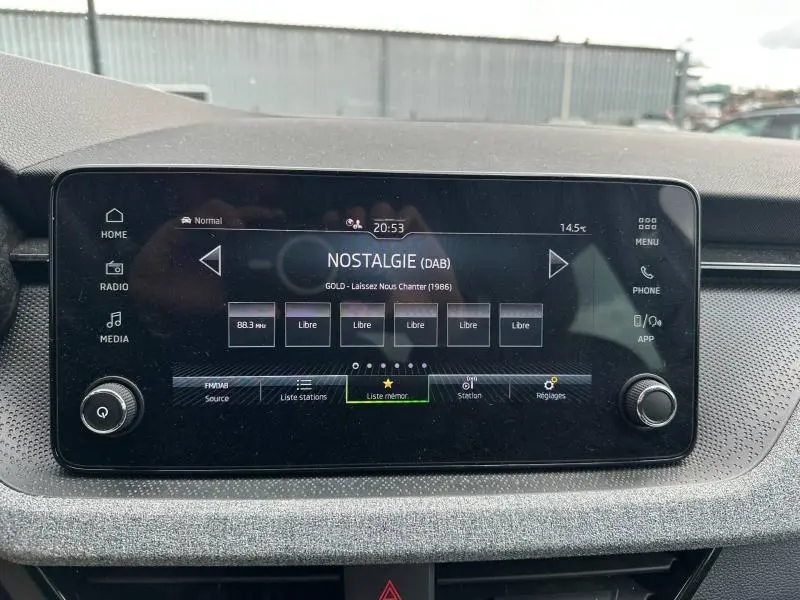 Écran tactile central du tableau de bord de la Skoda Scala blanc cristal, affichant la radio numérique DAB.