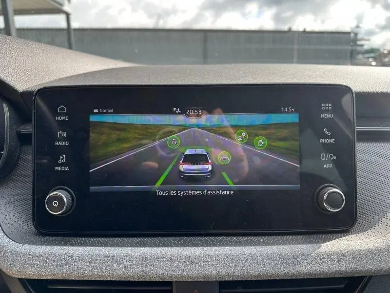 Écran tactile central montrant l'affichage des aides à la conduite dans une Skoda Scala blanche, vue intérieure frontale.