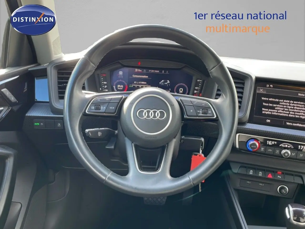 Vue intérieure centrée sur le volant cuir noir d'un Audi A1 Sportback 2023 avec tableau de bord digital et écran tactile.