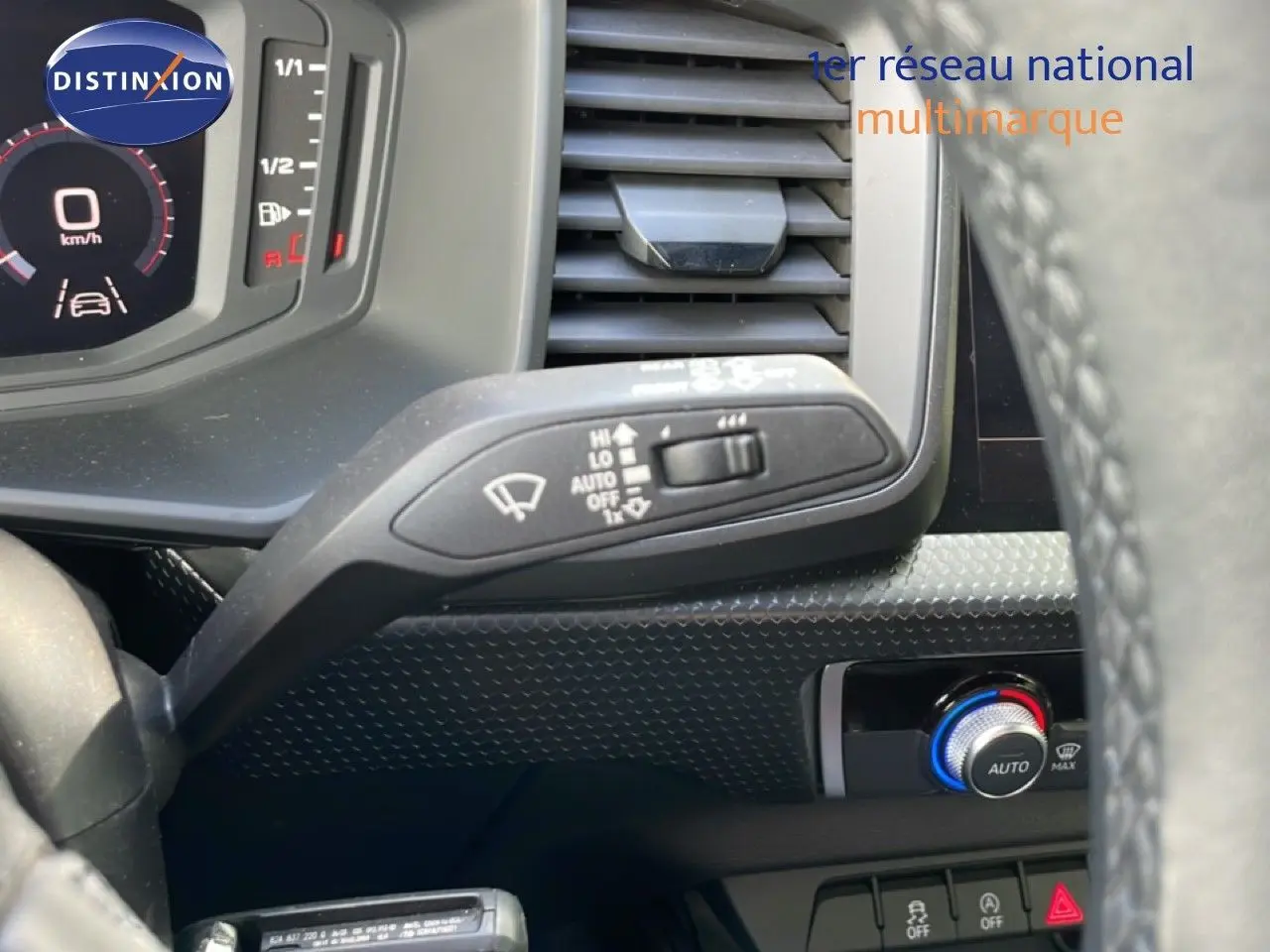 Détail du commodo d’essuie-glace et tableau de bord numérique d’une Audi A1 Sportback noire, vue intérieure côté conducteur.