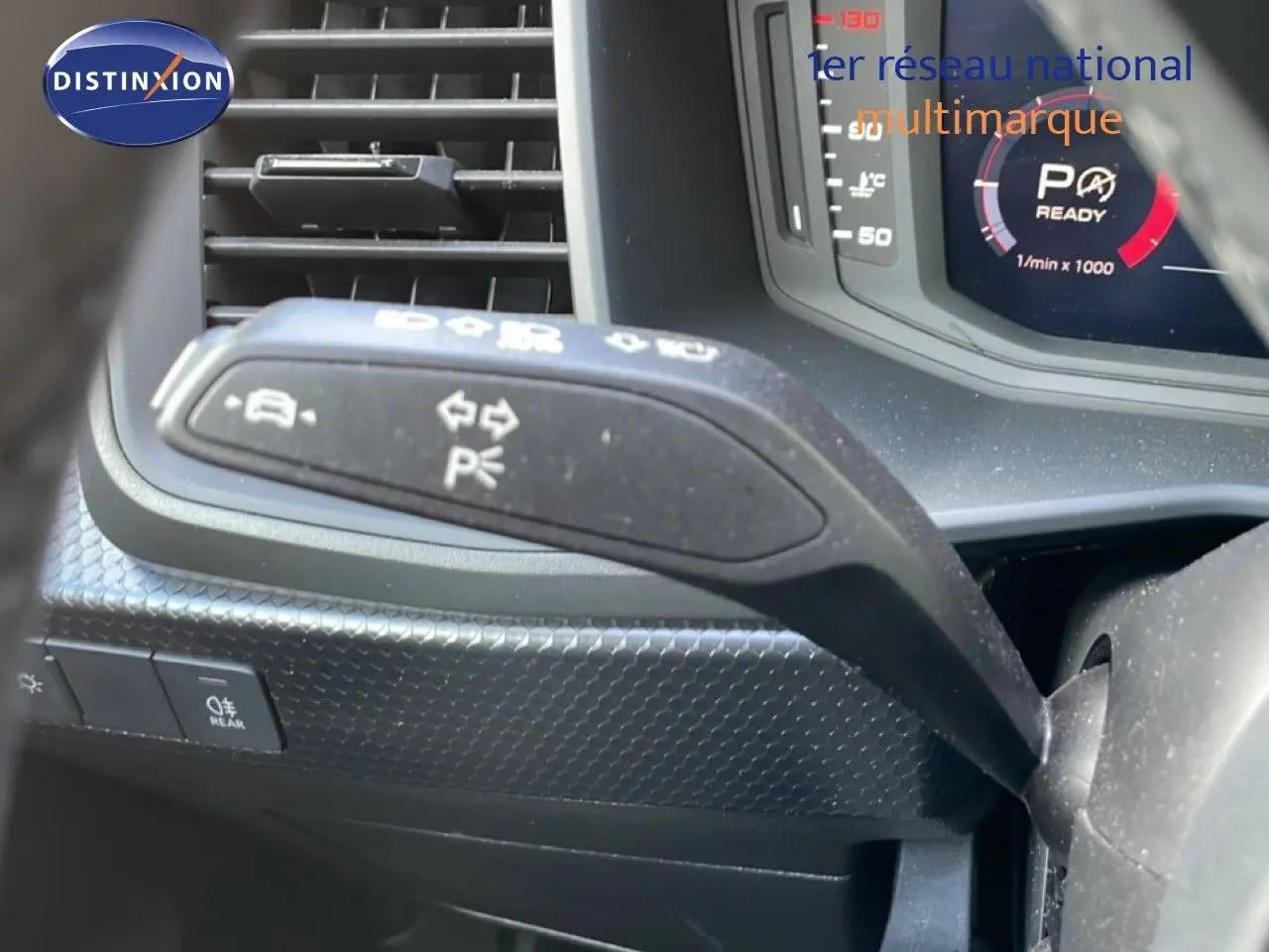 Gros plan sur la commande de clignotant à gauche dans l’habitacle noir de l’Audi A1 Sportback 2023.