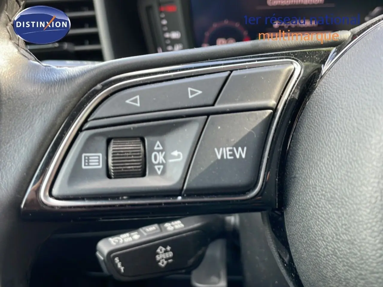 Gros plan sur les commandes au volant noir de l'Audi A1 Sportback 2023, mettant en valeur les boutons multifonctions.