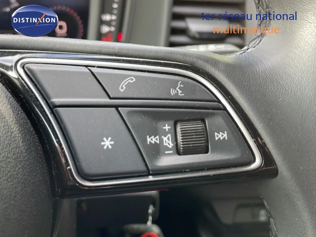 Gros plan sur les commandes au volant de l'Audi A1 Sportback noir Mythe Metal, mettant en valeur les boutons de volume et appel.