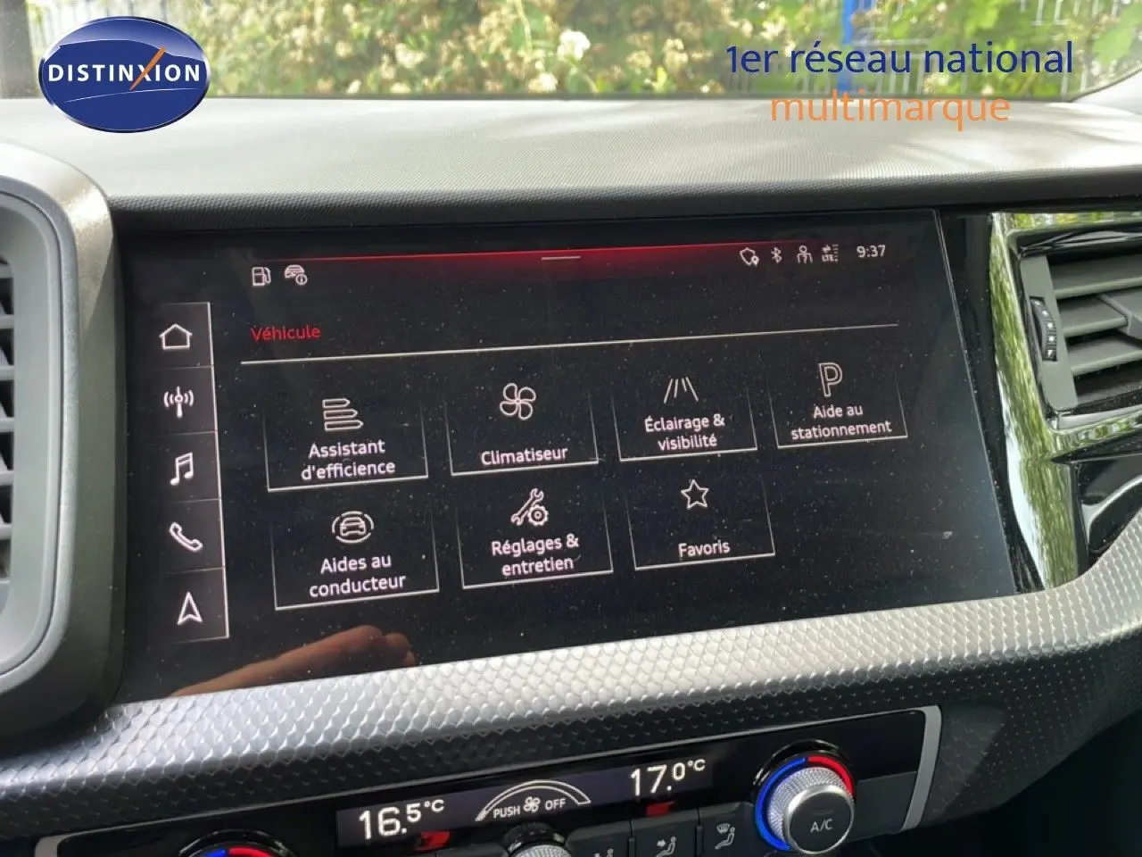 Écran tactile central de l’Audi A1 Sportback 2023 affichant les réglages du véhicule, avec tableau de bord noir et détails argentés.