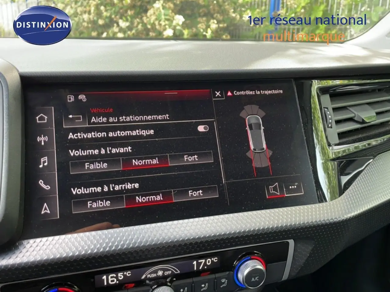 Vue rapprochée de l'écran tactile intérieur de l'Audi A1 Sportback 2023 noir, affichant l'aide au stationnement activée.
