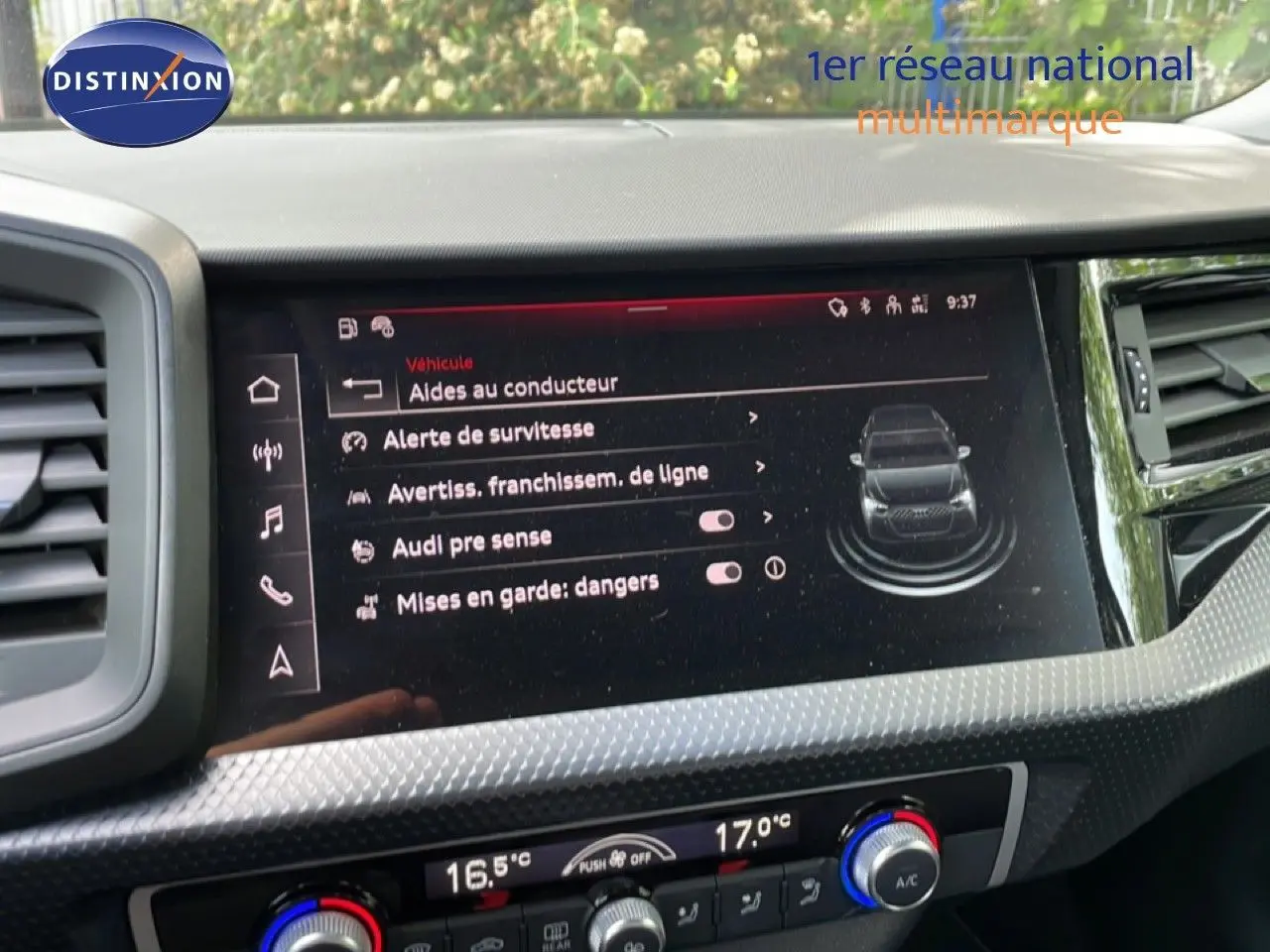 Écran central de l’Audi A1 Sportback 2023 affichant les aides à la conduite, avec tableau de bord noir et détails texturés.