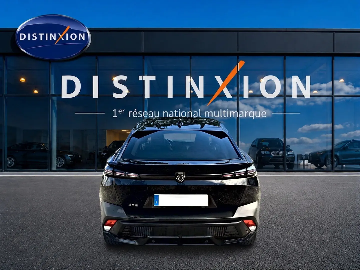 Vue arrière d'une Peugeot 408 Hybrid 145 allure e-dcs6 noire, avec feux LED et logo Peugeot bien visibles.