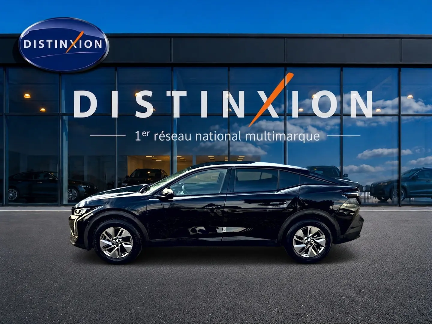Profil droit d'une Peugeot 408 Hybrid 145 allure e-dcs6 noire, avec jantes alu et vitres teintées, devant une vitrine Distinxion.