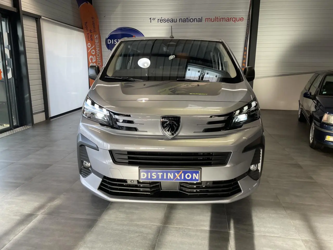 Vue frontale du Peugeot Expert Fourgon gris Artense, mettant en valeur sa calandre moderne et ses phares LED allumés.
