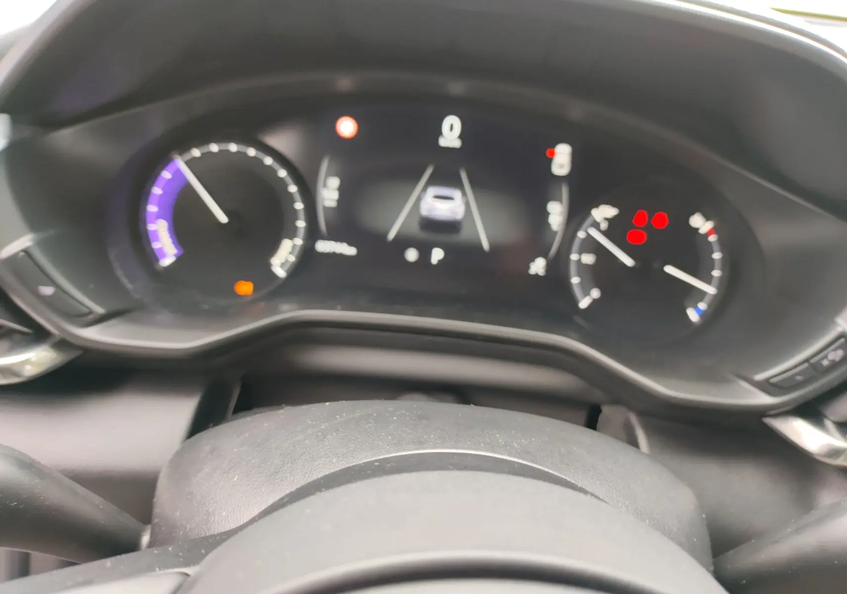 Vue rapprochée du tableau de bord numérique du Mazda MX-30 gris clair 2023, affichant les compteurs et alertes.