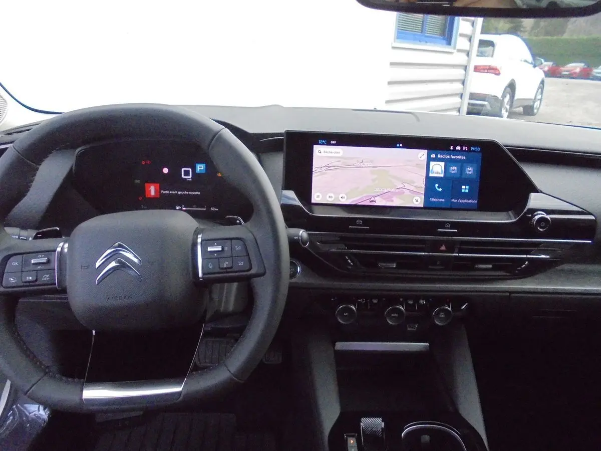 Vue intérieure du tableau de bord et volant du Citroën C5 X 2022, avec écran tactile et commandes au volant visibles.