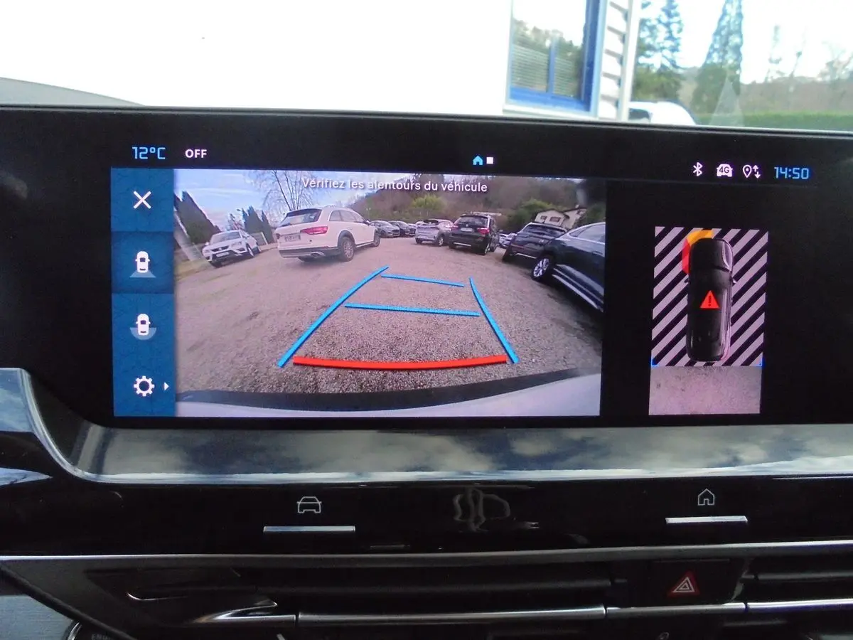 Écran intérieur de la Citroën C5 X blanc nacré montrant la caméra de recul et l'aide au stationnement active.