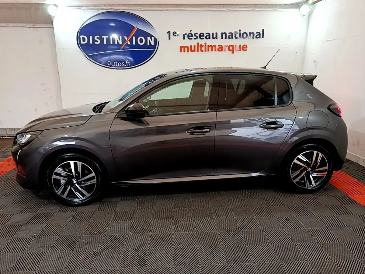 Peugeot 208 gris foncé vue de profil côté gauche, avec jantes alliage et poignées de porte ton caisse.