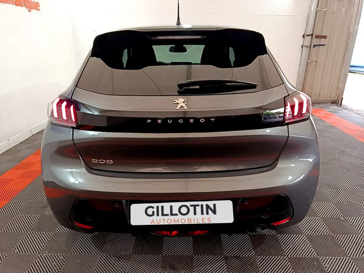 Vue arrière d’une Peugeot 208 gris foncé avec feux LED caractéristiques et logo Peugeot visible.