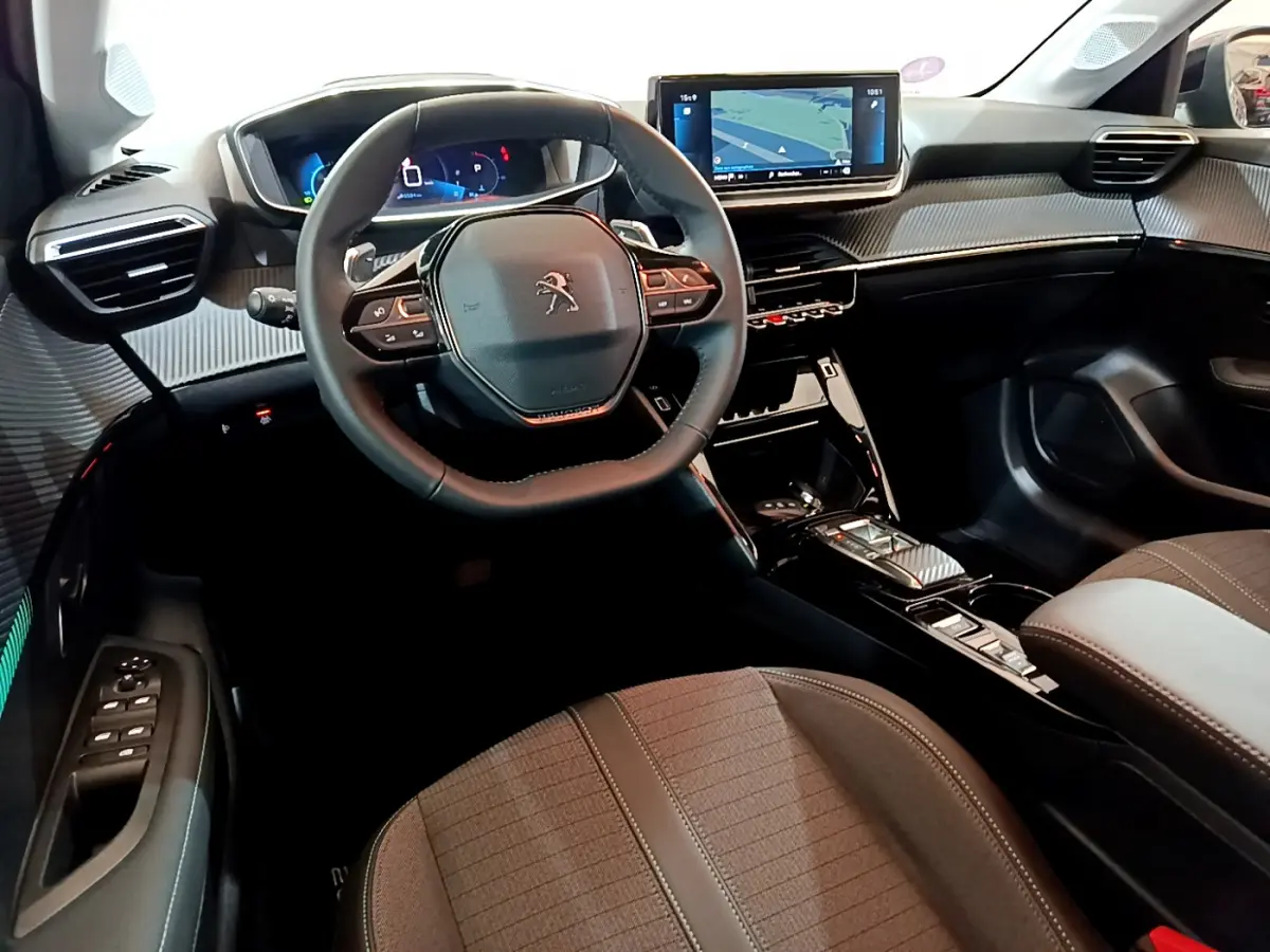 Intérieur de la Peugeot 208 2022 vu côté conducteur, volant cuir, tableau de bord numérique et écran tactile central.