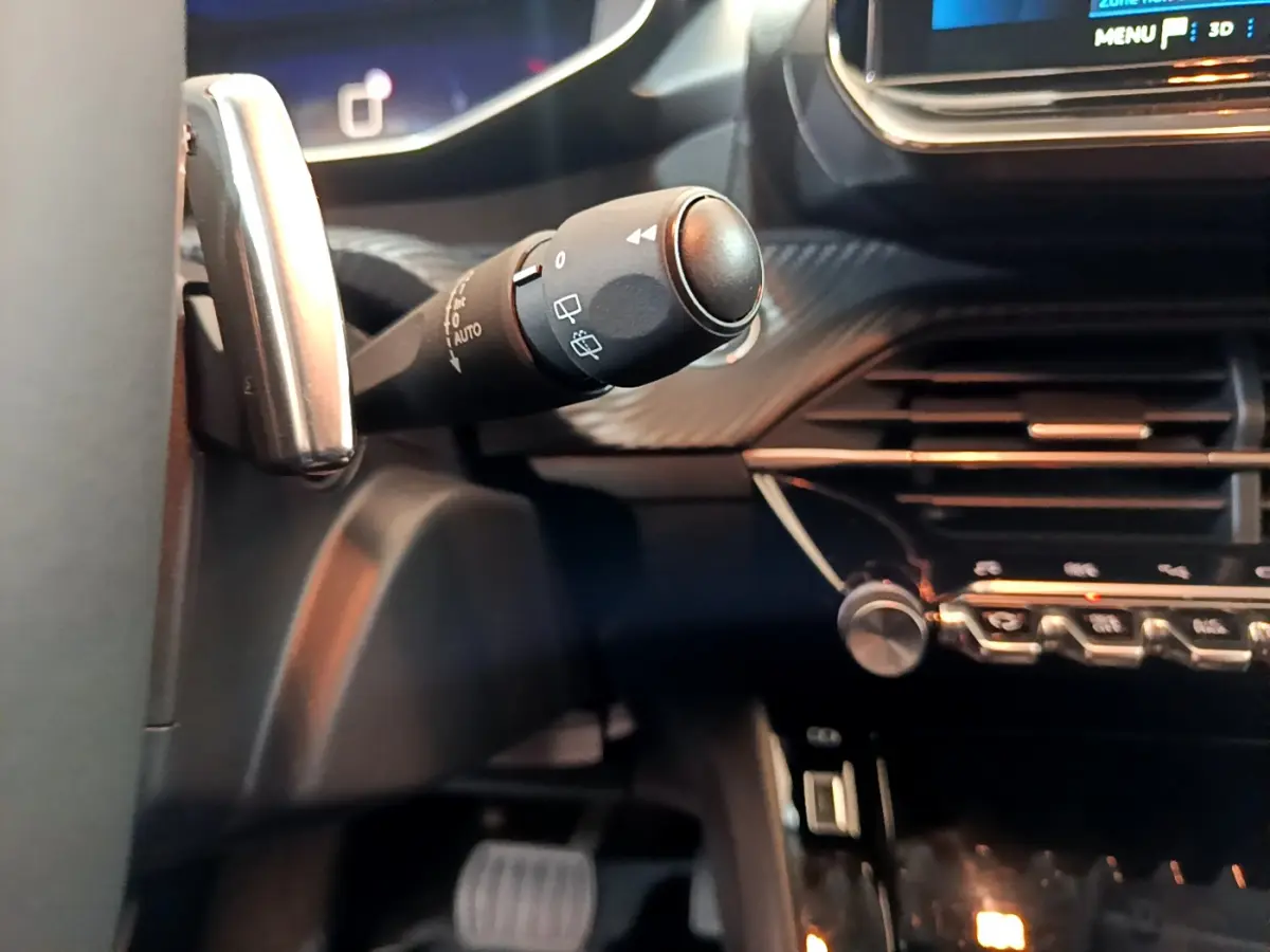 Gros plan sur la commande d’essuie-glace côté gauche du tableau de bord noir de la Peugeot 208 2022.