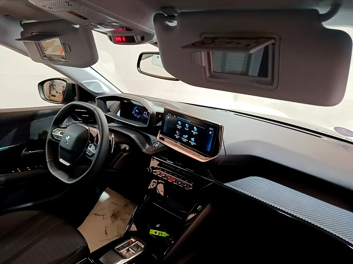 Vue intérieure côté conducteur de la Peugeot 208 gris foncé, avec tableau de bord numérique et écran tactile central.