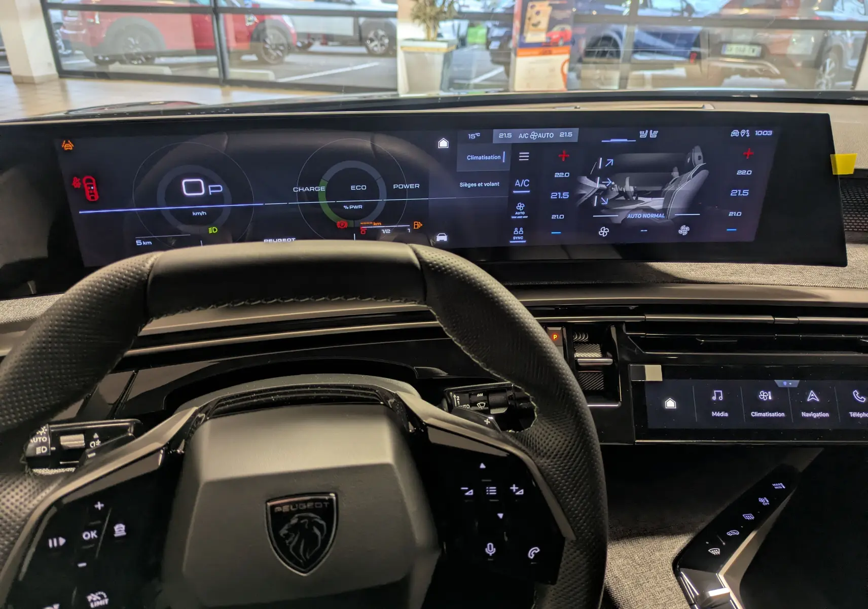 Vue intérieure centrée sur le tableau de bord et le volant noir du Peugeot 3008 Hybrid 145 GT, avec écran digital large.