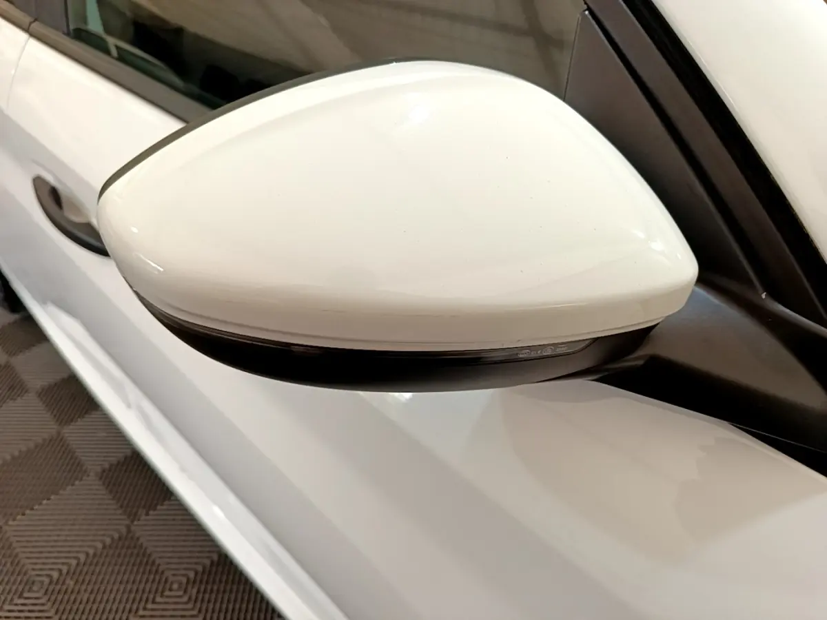Rétroviseur droit blanc de la Peugeot 208 1.2 PT 75 S&S Premium 2021, vue rapprochée sur la portière blanche.