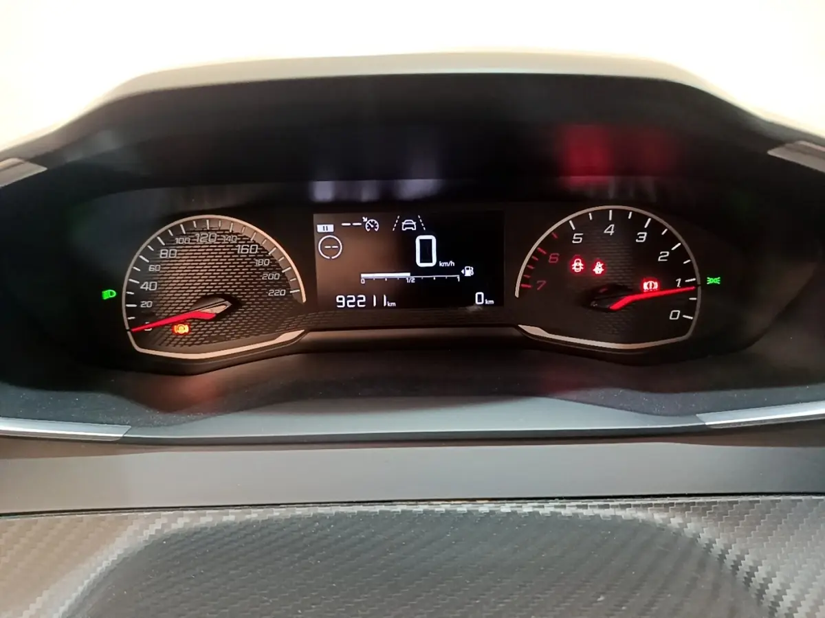 Tableau de bord de Peugeot 208 blanc, affichage numérique central avec compte-tours et vitesse à 0 km/h.