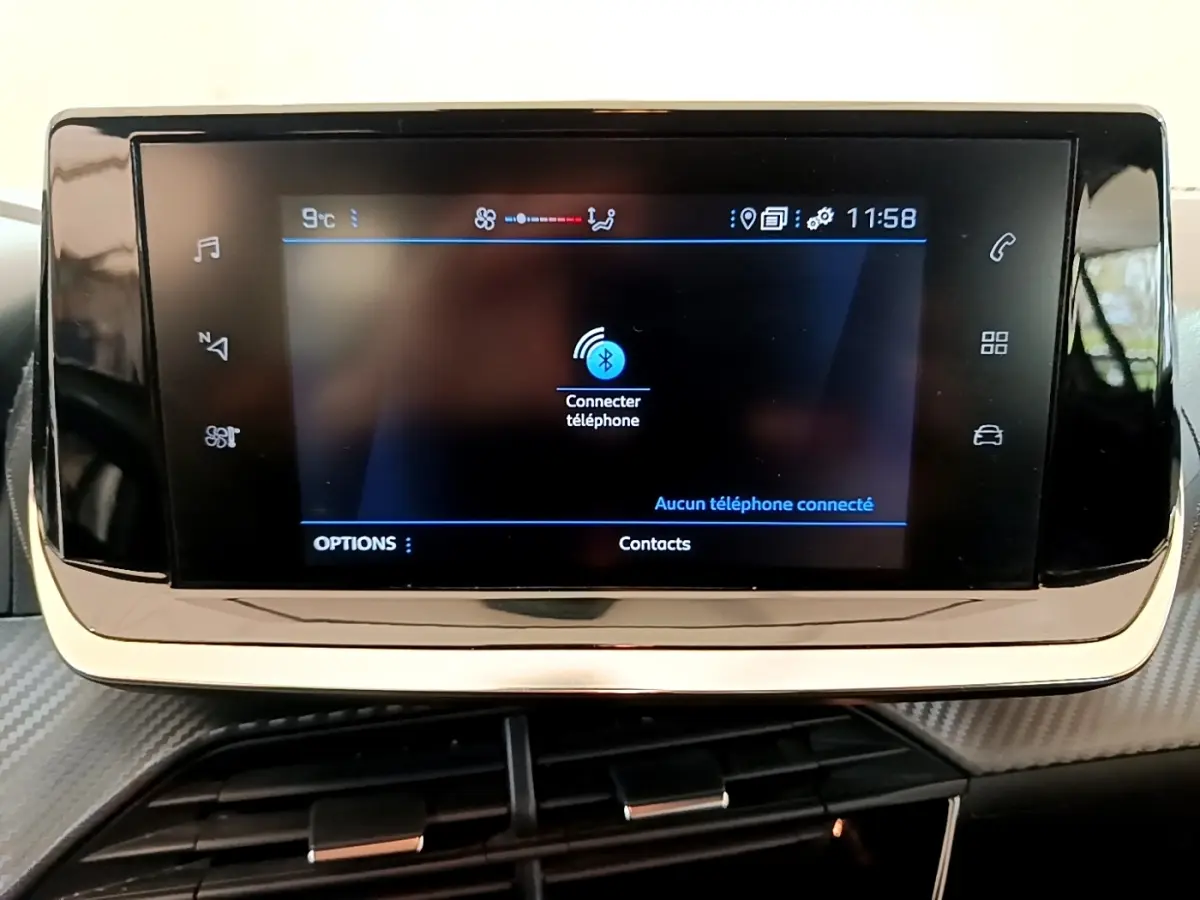 Écran tactile central de la Peugeot 208 blanc, affichant la connexion Bluetooth au téléphone, intérieur moderne.