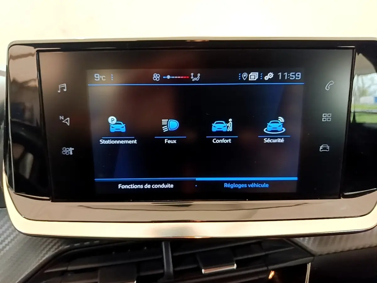 Écran tactile central de la Peugeot 208 2021 affichant les options stationnement, feux, confort et sécurité.