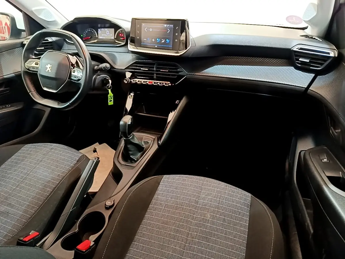 Intérieur de Peugeot 208 2021 vue côté conducteur, tableau de bord avec écran tactile et volant compact noir.