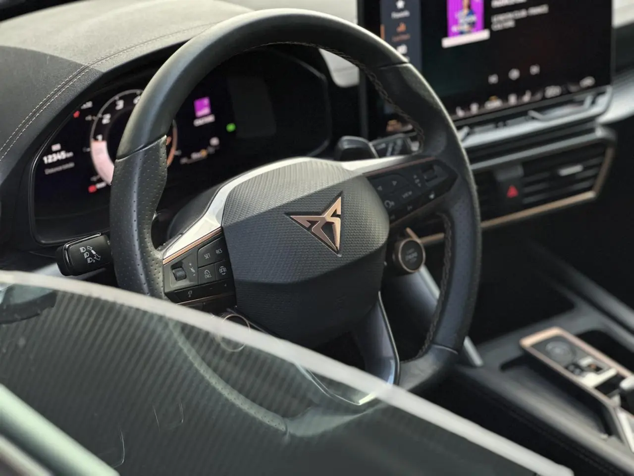 Vue rapprochée du volant cuir noir perforé avec logo CUPRA cuivré et tableau de bord numérique du Formentor 2025.