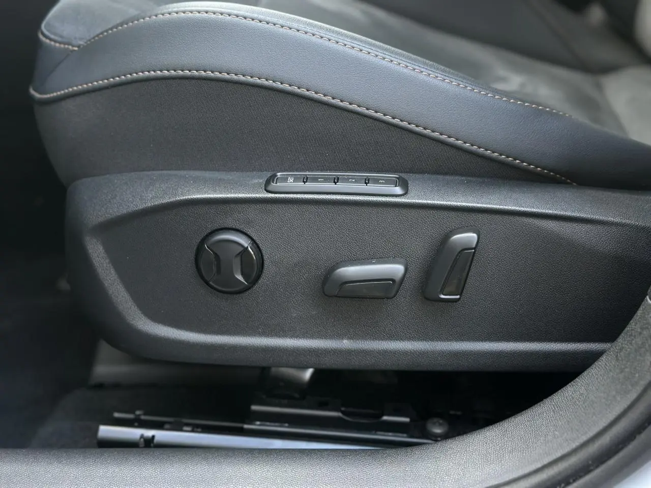Détail des commandes de réglage électrique du siège conducteur en suédine noir sur CUPRA Formentor blanc.