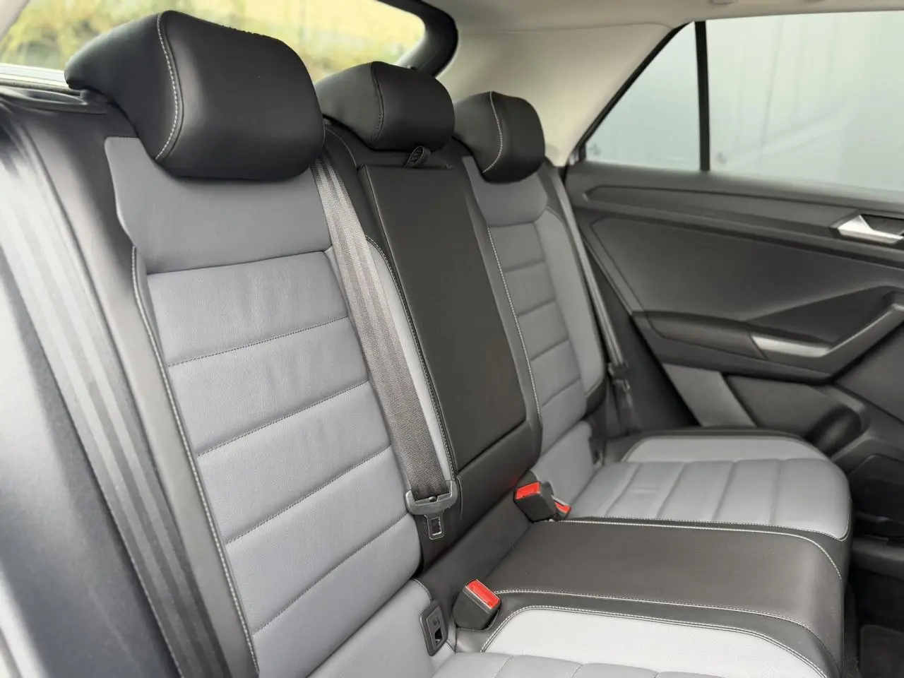 Vue latérale intérieure des sièges arrière en cuir gris et noir du Volkswagen T-Roc 2024 Style Exclusive.